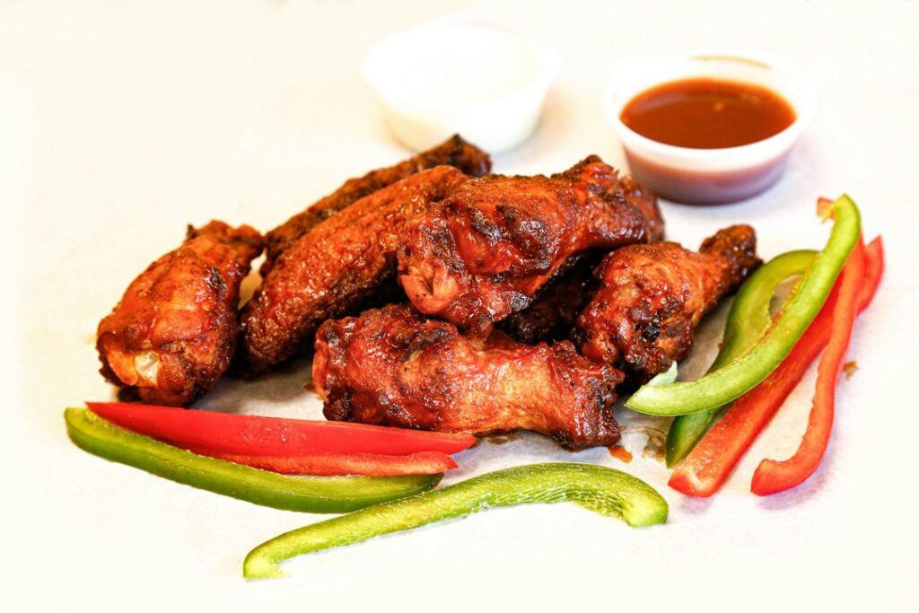 Chicken wings with vegetables and dipping sauces; illustrative meal, not a Wingstop product photo