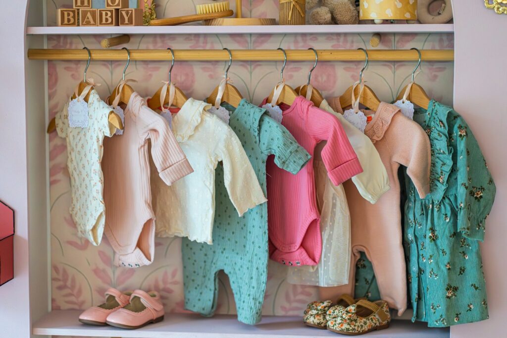 Children's clothing hanging on a rack with shoes below