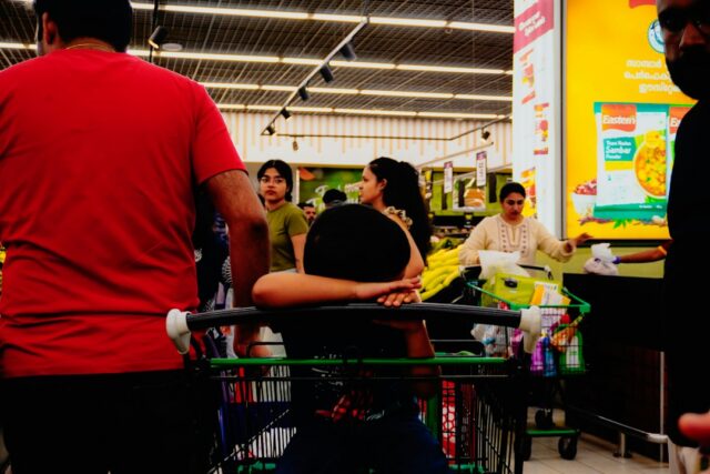 shopper planning a Dollar General 5 off 25 coupon basket in a bright store aisle