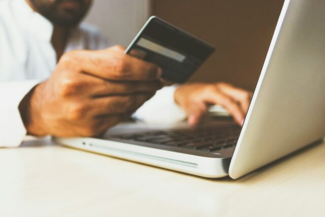 Person shopping online with a payment card, illustrating subscription checkout decisions