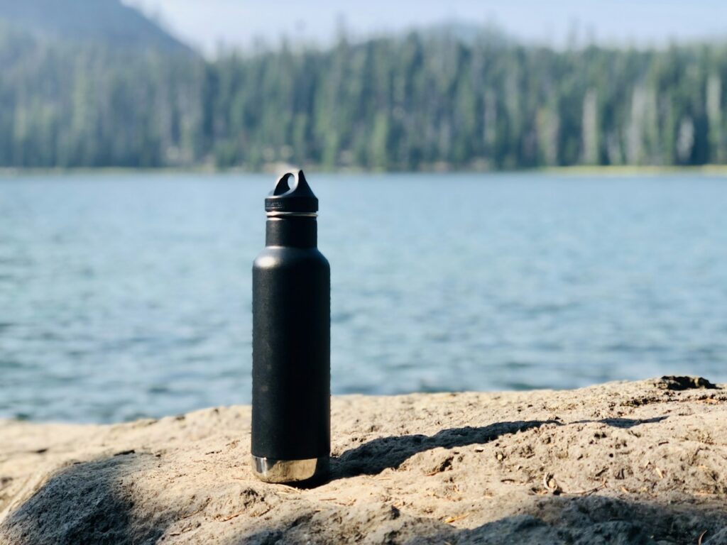 Reusable water bottle beside a lake