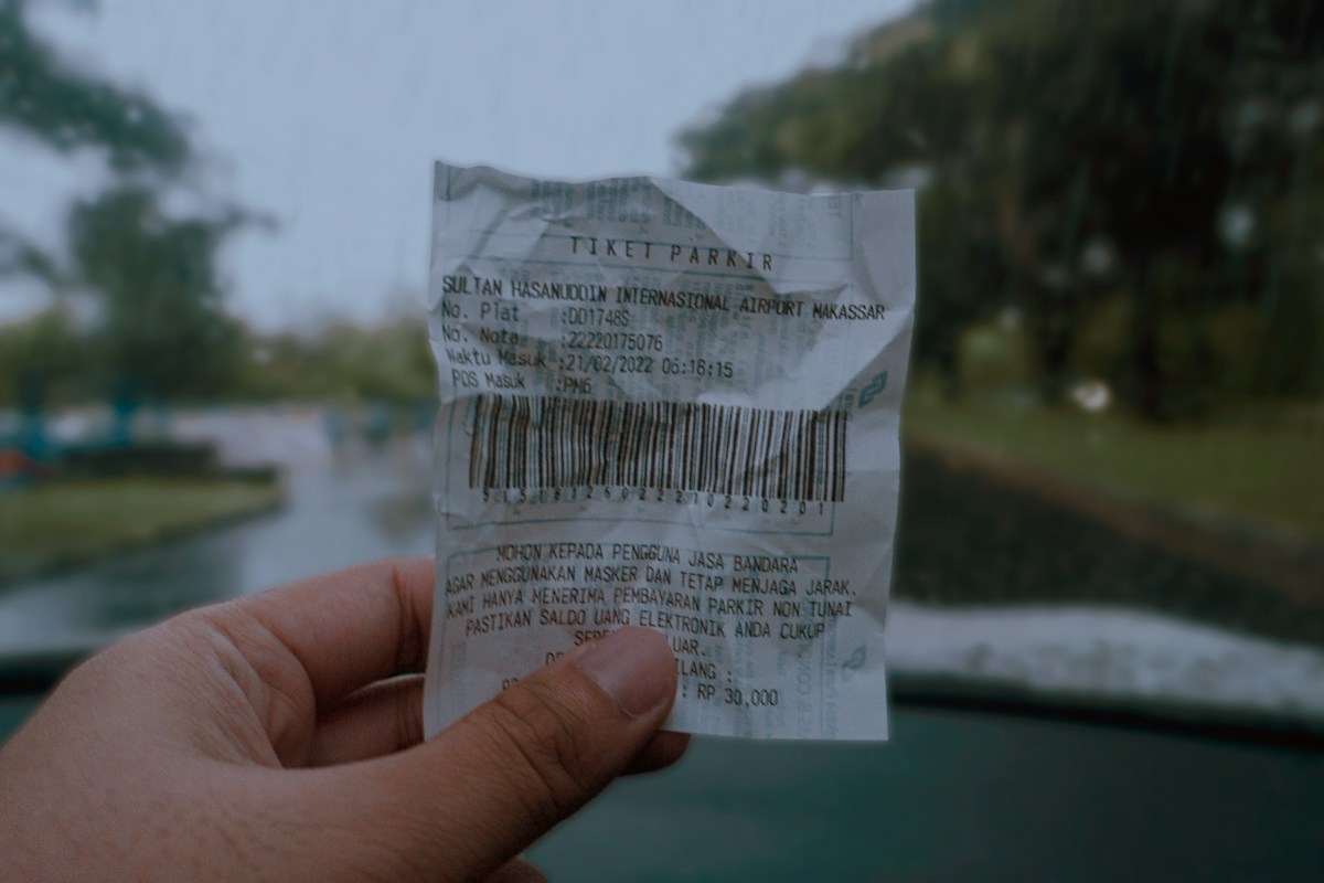 A hand holding a printed receipt, illustrative shopping photograph