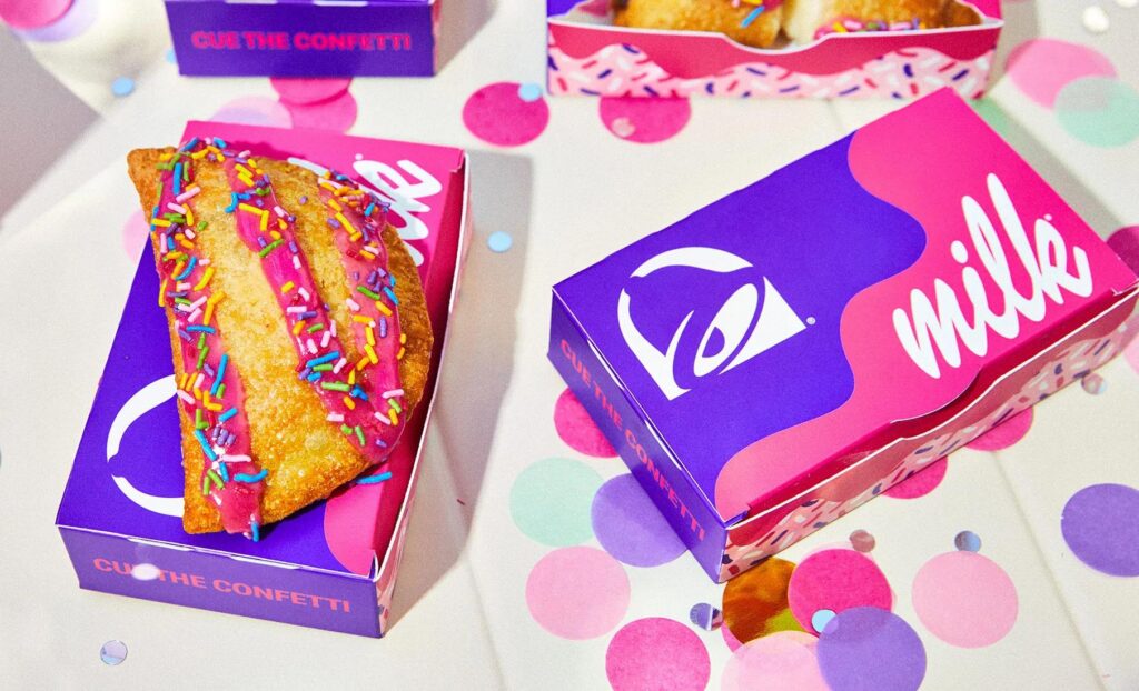 Taco Bell Milk Bar Birthday Cake Empanada with pink frosting and rainbow sprinkles