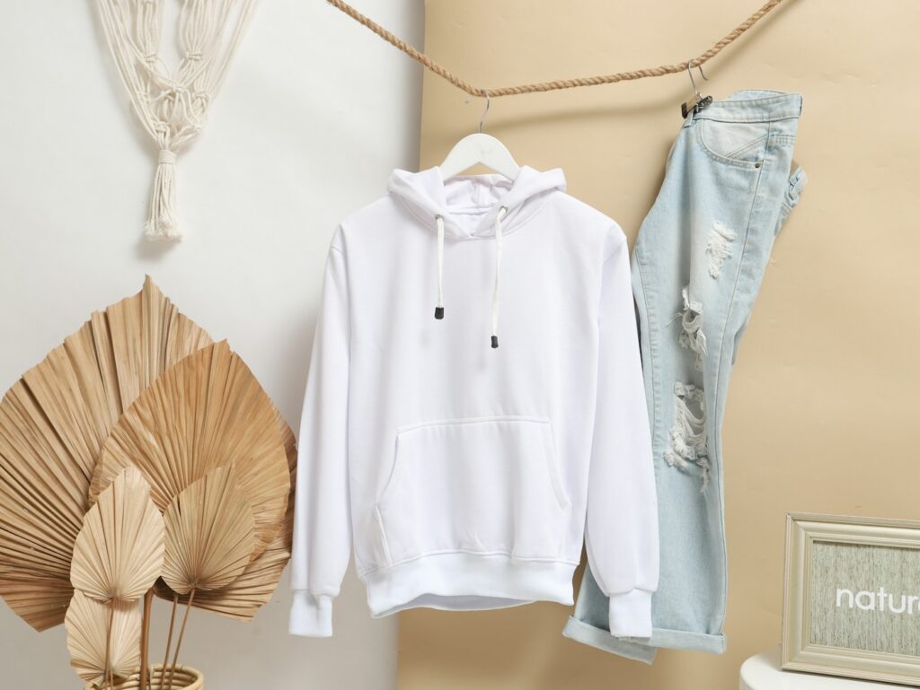 Illustrative white hoodie hanging with jeans