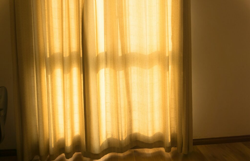 Curtains hanging beside a sunlit window