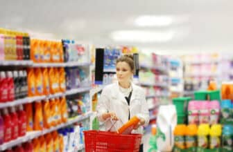 Woman shopping in supermarket reading product information.woman choosing laundry detergent in supermarket